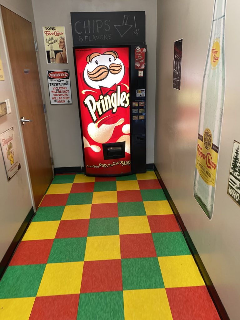 Press one of the buttons on the Pringles machine, and wait for a host to greet you from behind the machine!